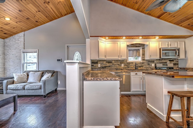 kitchen featuring white cabinetry, dark countertops, a ceiling fan, and stainless steel appliances