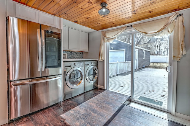 washroom featuring dark wood finished floors, laundry area, washing machine and dryer, and wooden ceiling