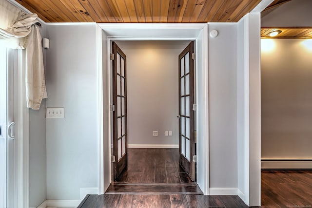 corridor with a baseboard radiator, baseboards, dark wood-style floors, and wooden ceiling