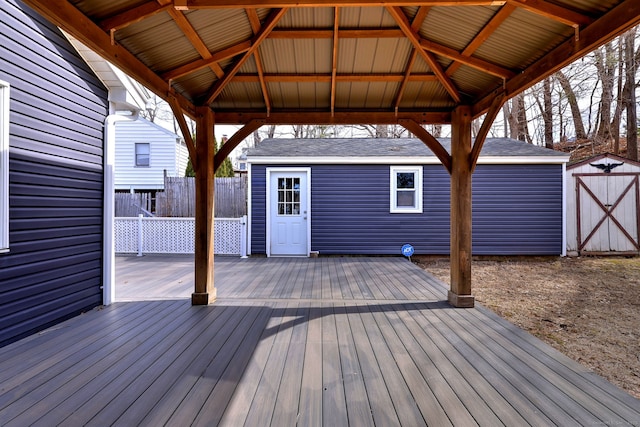 deck featuring a gazebo, an outbuilding, and fence