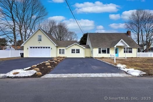 view of front of property with a chimney, fence, and aphalt driveway