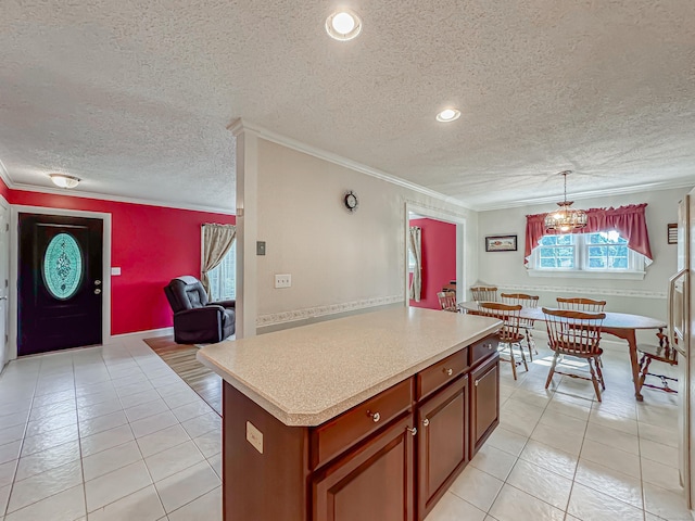 kitchen with brown cabinets, a kitchen island, light countertops, and crown molding