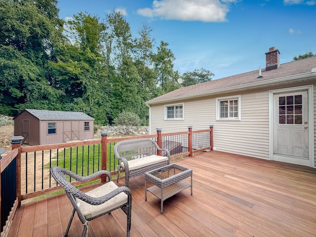 wooden deck featuring a yard, a shed, an outdoor living space with a fire pit, and an outbuilding