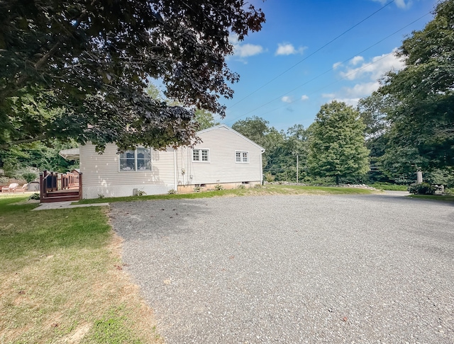 view of front facade featuring a front lawn and gravel driveway