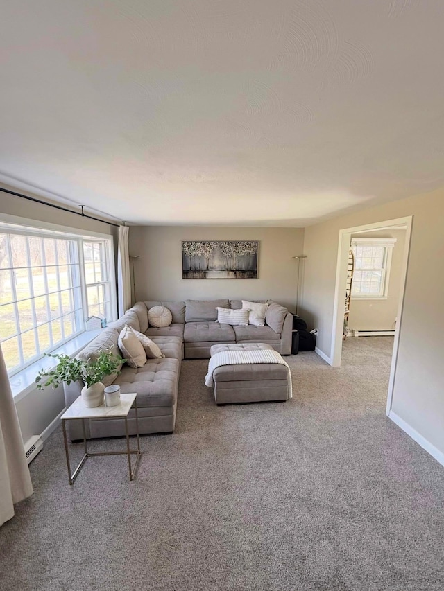 carpeted living area with baseboard heating and baseboards