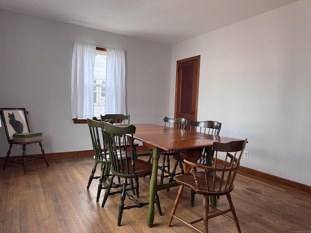 dining area featuring baseboards and hardwood / wood-style flooring