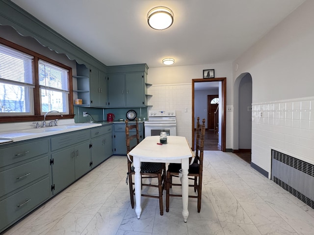 kitchen featuring marble finish floor, white range with electric cooktop, open shelves, a sink, and radiator