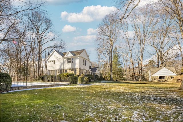 view of home's exterior featuring stone siding, a yard, and fence