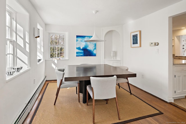 dining area with light wood-style floors and a baseboard radiator