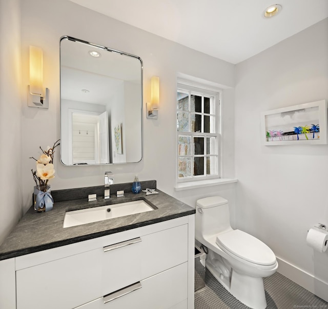 half bath with tile patterned flooring, toilet, recessed lighting, vanity, and baseboards