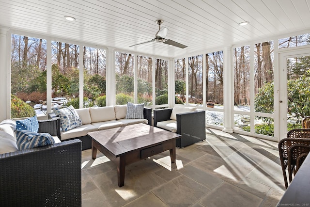 sunroom featuring a ceiling fan, wood ceiling, and ornate columns