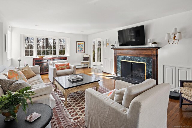 living area featuring hardwood / wood-style flooring, a fireplace, and arched walkways