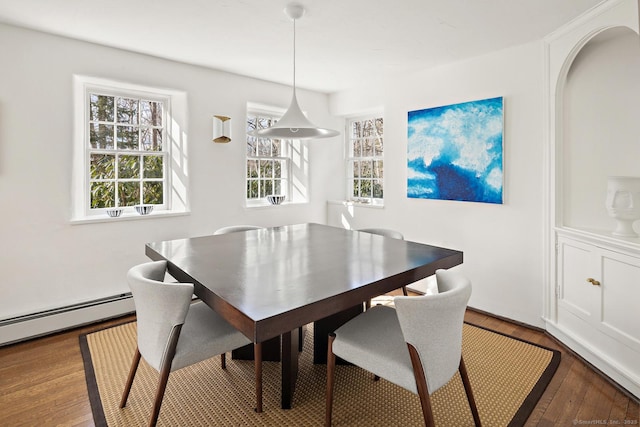 dining area featuring a baseboard radiator and wood finished floors