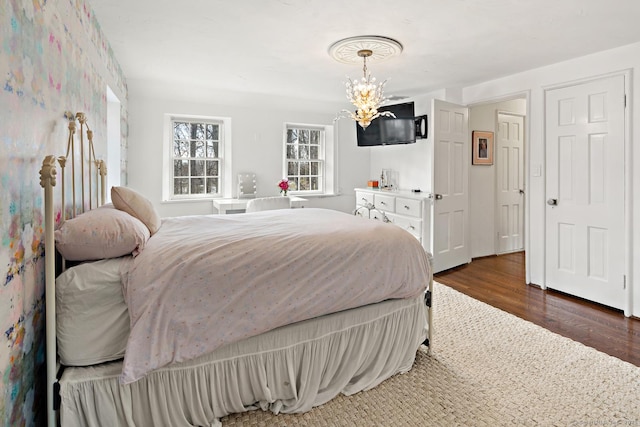 bedroom with a chandelier and wood finished floors