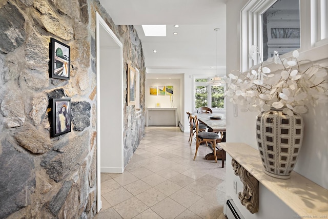 hall featuring a skylight, light tile patterned flooring, and recessed lighting