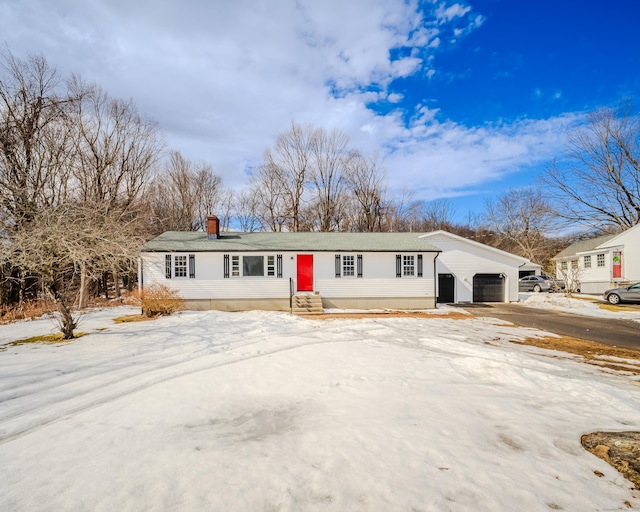 ranch-style home with a garage, an outbuilding, and entry steps