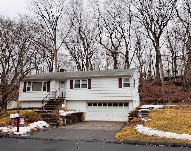 bi-level home with an attached garage and aphalt driveway