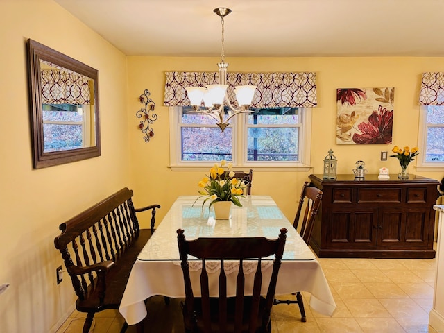 dining area featuring light tile patterned floors and an inviting chandelier