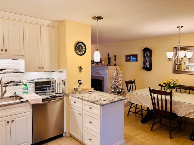 kitchen featuring a fireplace, decorative backsplash, a sink, dishwasher, and a peninsula