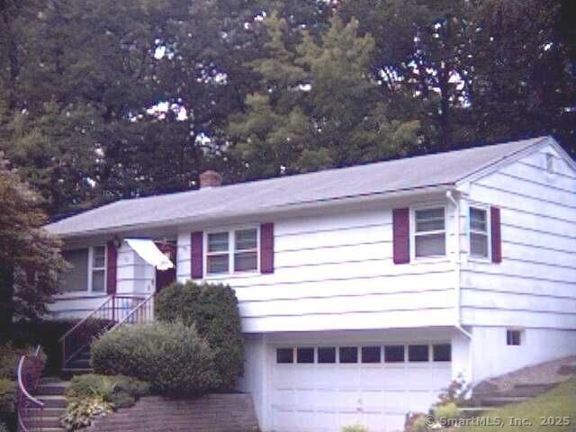 view of front facade with a garage and a chimney