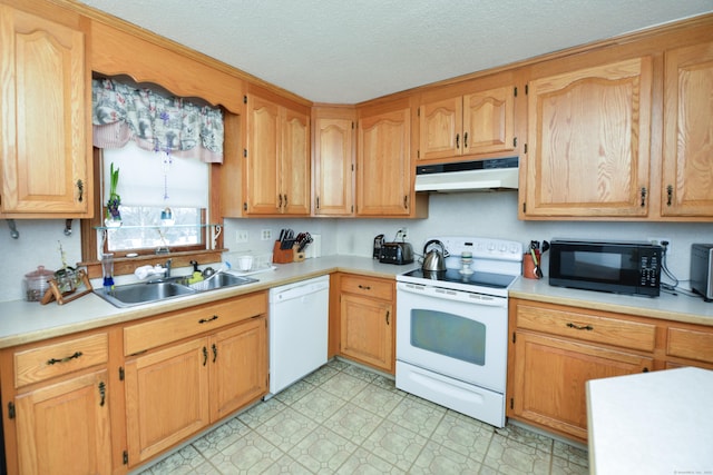 kitchen featuring light floors, light countertops, a sink, white appliances, and under cabinet range hood