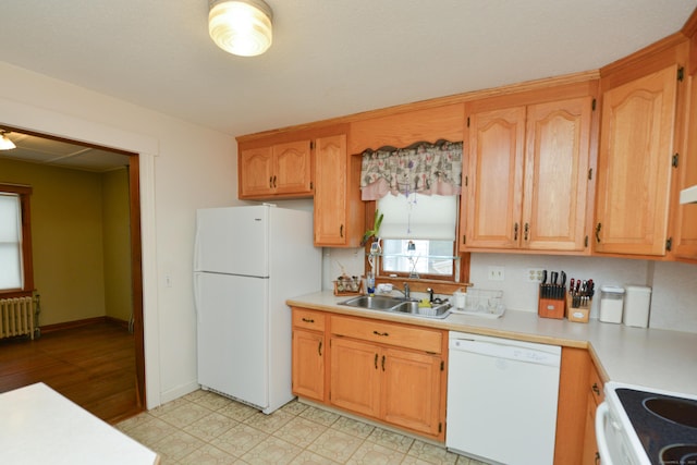 kitchen featuring light countertops, white appliances, radiator heating unit, and a sink