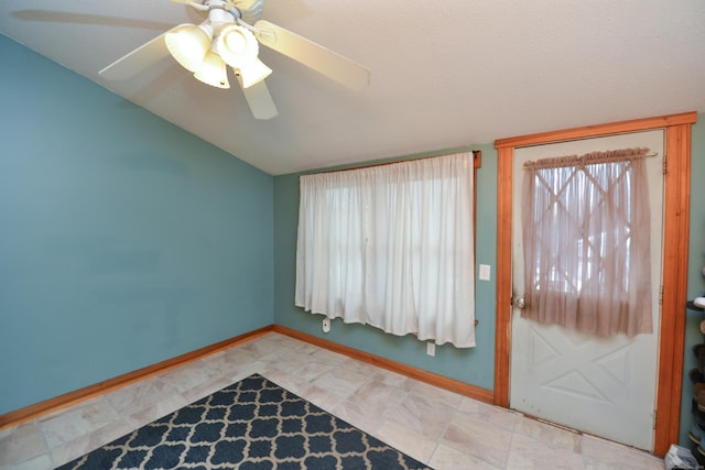 empty room featuring lofted ceiling and baseboards