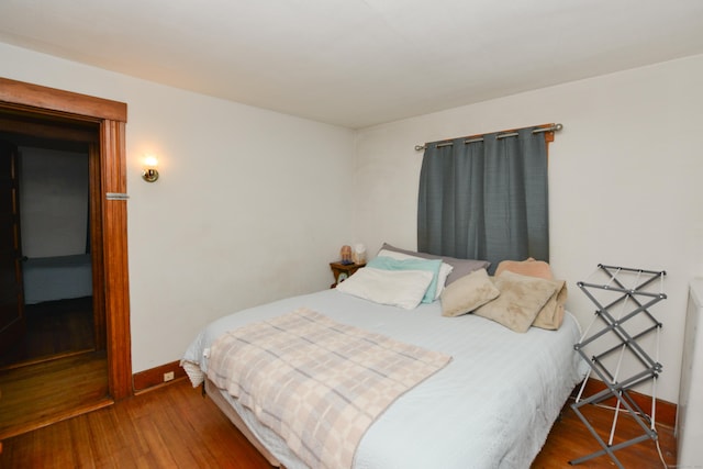 bedroom featuring wood finished floors and baseboards