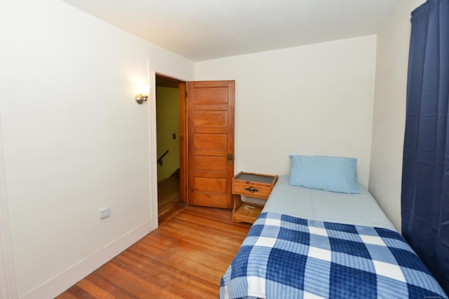 bedroom with baseboards and light wood finished floors