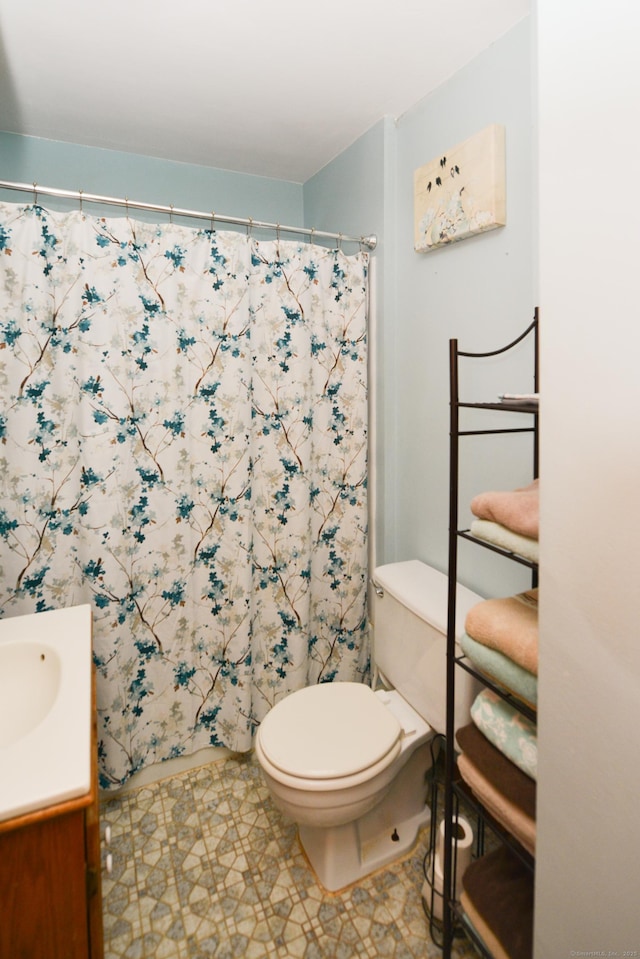 bathroom with toilet, curtained shower, and vanity