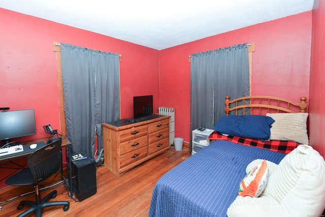 bedroom featuring radiator heating unit and wood finished floors