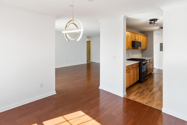 kitchen with black appliances, baseboards, light countertops, and dark wood-type flooring