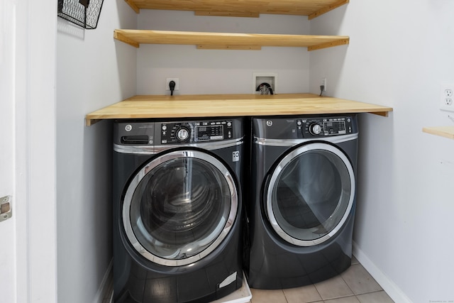 laundry area with light tile patterned floors, laundry area, baseboards, and washer and clothes dryer