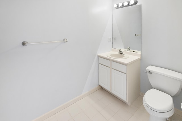 half bath featuring vanity, toilet, and baseboards