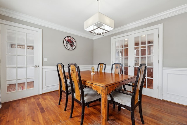 dining room featuring ornamental molding, wainscoting, and hardwood / wood-style floors