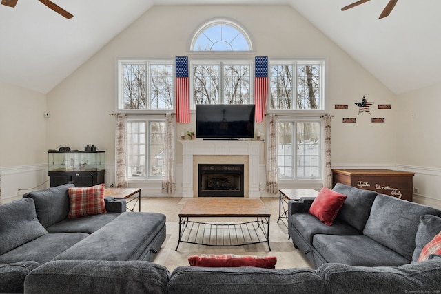 living room with a wealth of natural light, a fireplace, high vaulted ceiling, and a ceiling fan