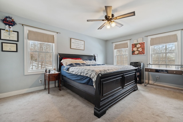 bedroom with light carpet, baseboards, and multiple windows