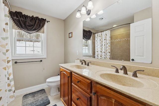 bathroom featuring tile patterned flooring, baseboards, a sink, and toilet