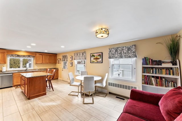 dining space with a healthy amount of sunlight, radiator heating unit, baseboards, and recessed lighting