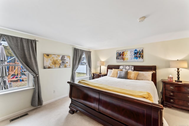 bedroom featuring baseboards, visible vents, and light colored carpet