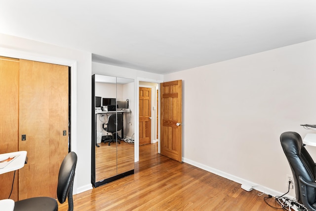 office space featuring baseboards and light wood finished floors