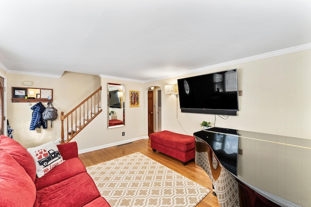 living room with arched walkways, visible vents, stairway, and wood finished floors