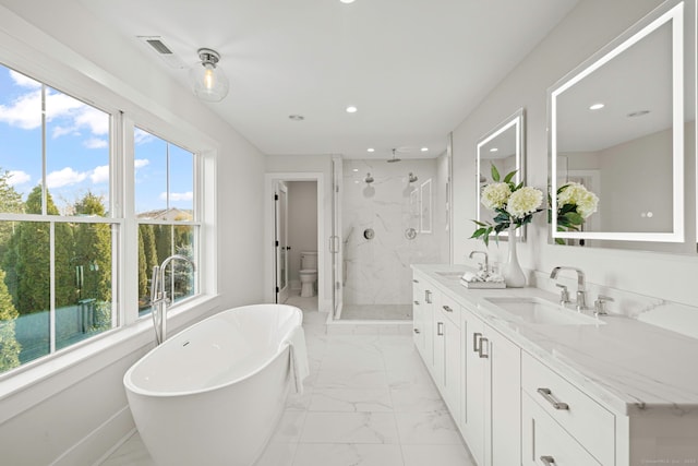 full bathroom featuring a stall shower, marble finish floor, a sink, and toilet