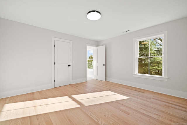 unfurnished room with visible vents, baseboards, and wood finished floors