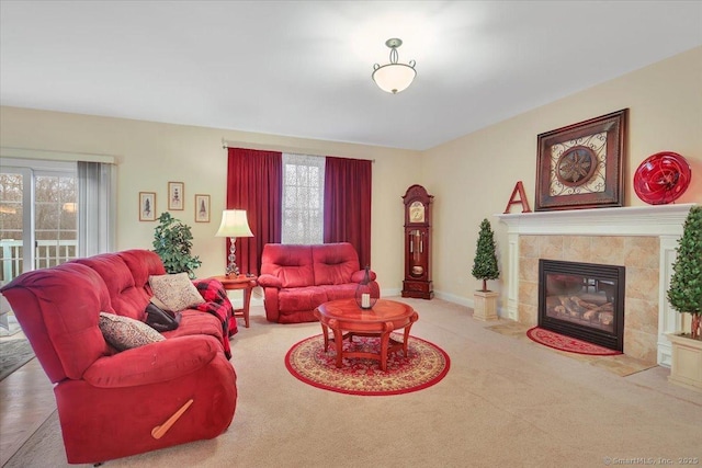 living room featuring carpet floors, a fireplace, baseboards, and a wealth of natural light