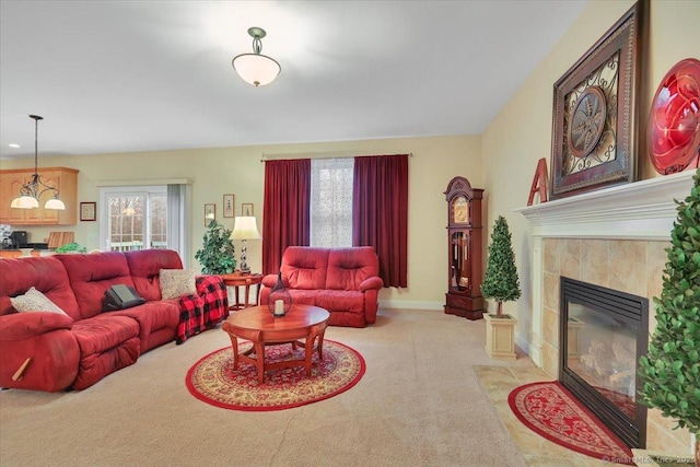 living area with a tile fireplace, light colored carpet, and baseboards