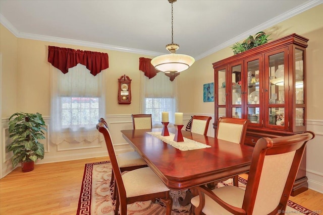 dining space with a healthy amount of sunlight, light wood-style flooring, and crown molding