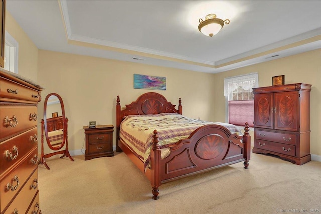 bedroom featuring light colored carpet, a tray ceiling, visible vents, and baseboards