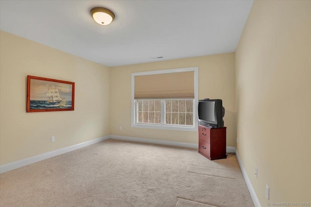 empty room featuring light colored carpet, visible vents, and baseboards