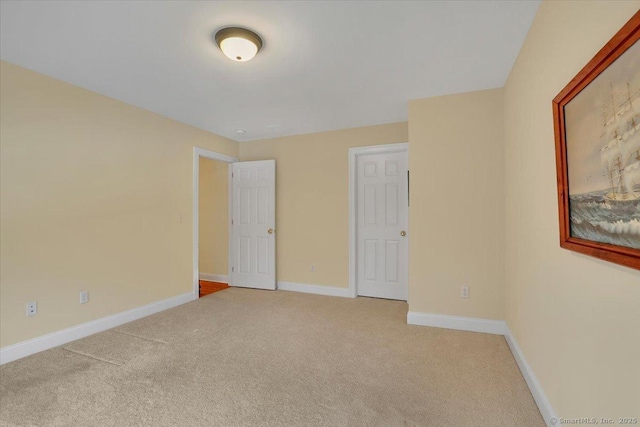 unfurnished bedroom featuring carpet and baseboards